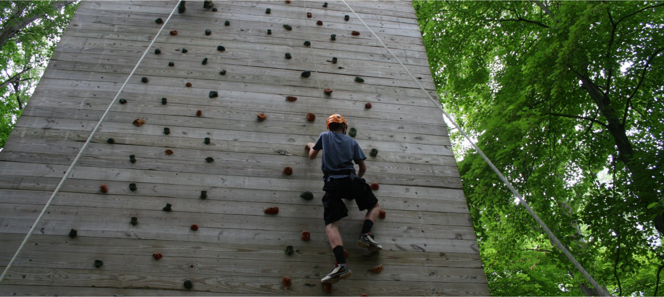 kid climbing wall at Youth Leadership Camp
