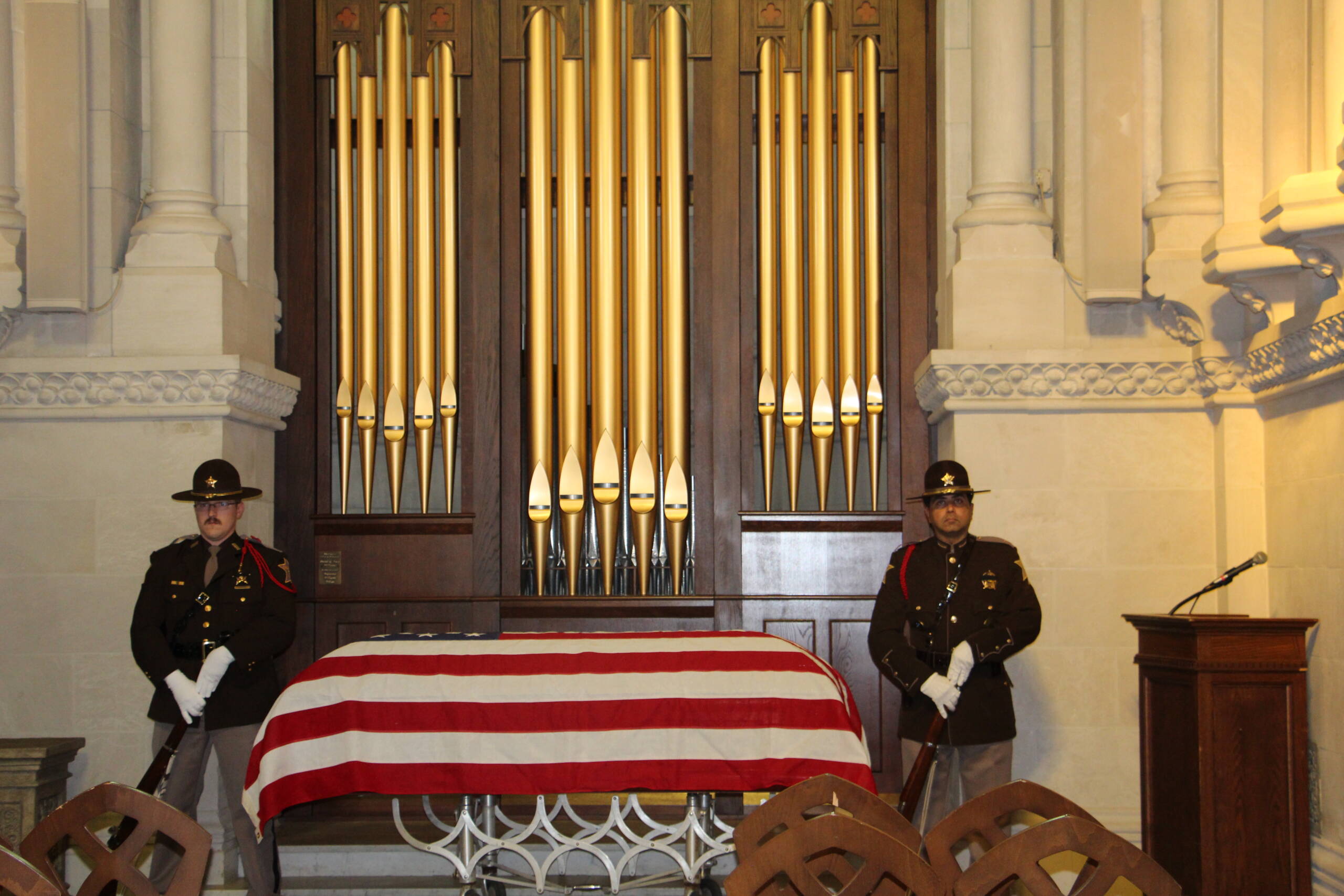 Honor guards with flag covered casket.