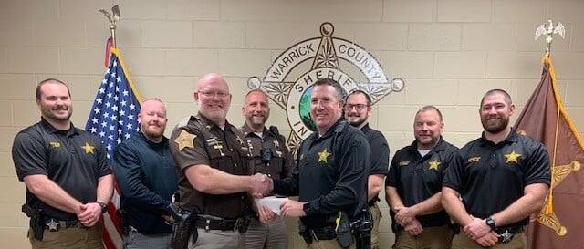 Sheriff's shaking hangs with donation paper.